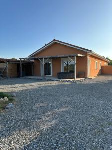 a house with a gravel driveway in front of it at maison au calme in Maubourguet