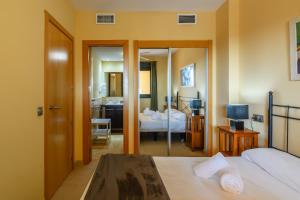 ein Hotelzimmer mit einem Bett und einem Badezimmer in der Unterkunft Playa Marina by Ĥ - Playa Punta del Moral PPHM303P59 in Punta del moral