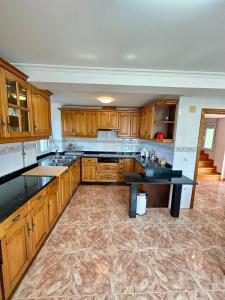 Una cocina con gabinetes de madera y una encimera negra. en La Ponderosa, en Castañeras