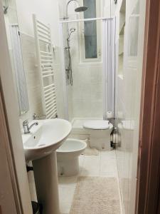 a white bathroom with a sink and a toilet at Casa Vacanze Angelina in Trieste