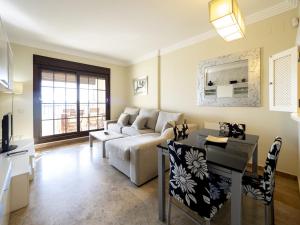a living room with a couch and a table at Los Pelicanos by Ĥ - Playa Punta del Moral PLHC39P38 in Isla del Moral