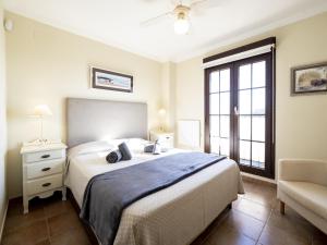 a bedroom with a bed and a chair and a window at Los Pelicanos by Ĥ - Playa Punta del Moral PLHC39P38 in Isla del Moral +31 photos