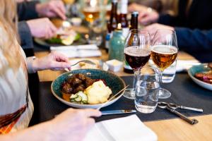 a table with a bowl of food and glasses of wine at STF Långholmen Hostel in Stockholm