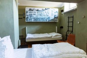 ein Schlafzimmer mit zwei Betten und einem Gemälde an der Wand in der Unterkunft STF Långholmen Hostel in Stockholm
