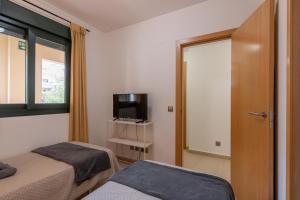 A television and/or entertainment centre at Playa Marina by Ĥ