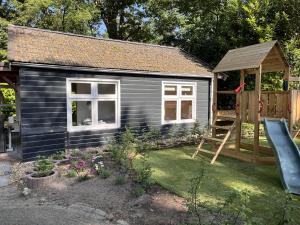 a small house with a slide and a playground at Buitengewoon Beerze in Beerze