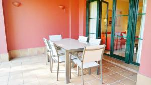 a dining room with a table and white chairs at El Rincón del Golf I by Ĥ - Isla Canela Golf GRHI6P06 in Isla Canela