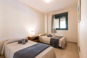 A bed or beds in a room at Playa Marina by Ĥ