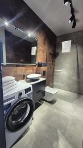 a bathroom with a washing machine and a sink at Apartament Baltic 21 Mielno in Mielno +27 photos