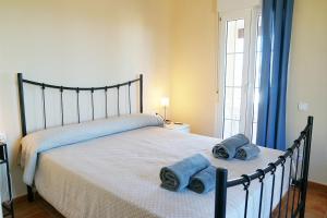 a bedroom with a bed with towels on it at Canela Park by Ĥ - Playa Isla Canela ICHP34P3 in Isla Canela +25 photos