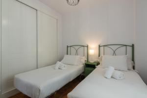 zwei Betten in einem Zimmer mit weißen Wänden in der Unterkunft Marina I PLUS by Ĥ - Marina Isla Canela PMHI57P28 in Punta del moral + 17 Fotos