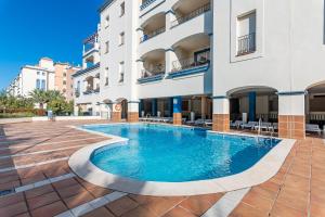 ein Schwimmbad vor einem Gebäude in der Unterkunft Marina I PLUS by Ĥ - Marina Isla Canela PMHI57P28 in Punta del moral