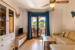 ein Wohnzimmer mit Sofa und Fernseher in der Unterkunft Playa Marina by Ĥ - Playa Punta del Moral PPHM218P41 in Punta del moral