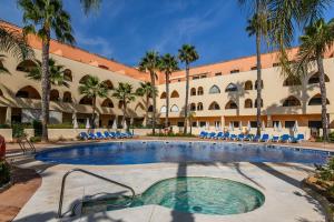 einen Pool vor einem Hotel mit Palmen in der Unterkunft Playa Marina by Ĥ - Playa Punta del Moral PPHM218P41 in Punta del moral