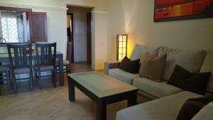 ein Wohnzimmer mit Sofa und Tisch in der Unterkunft Las Marismas by Ĥ - Isla Canela Golf GLHM117P134 in Isla Canela
