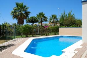 a swimming pool in a yard with palm trees at Marina III by Ĥ - Marina Isla Canela PMHIII12P13 in Isla del Moral