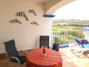 a room with a table and chairs and a balcony at Marina III by Ĥ - Marina Isla Canela PMHIII12P13 in Isla del Moral