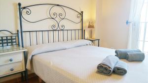 a bedroom with a bed with towels on it at Marina III by Ĥ - Marina Isla Canela PMHIII12P13 in Isla del Moral +15 photos