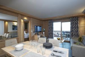 Un comedor con una mesa y una sala de estar. en MGM Hôtels & Résidences - Résidence Alpen Lodge, en La Rosière 56 fotos más