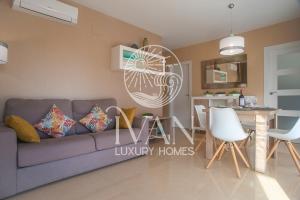 ein Wohnzimmer mit einem lila Sofa und einer Küche in der Unterkunft Casa Cristal Ivan Luxury Homes 5ªPlta Sur 1ªLinea in Oropesa del Mar