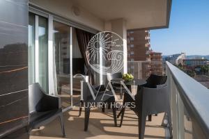einen Tisch und Stühle auf dem Balkon eines Gebäudes in der Unterkunft Casa Cristal Ivan Luxury Homes 5ªPlta Sur 1ªLinea in Oropesa del Mar