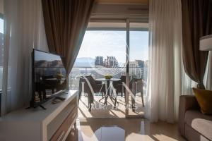 ein Wohnzimmer mit Fernseher und Tisch mit Stühlen in der Unterkunft Casa Cristal Ivan Luxury Homes 5ªPlta Sur 1ªLinea in Oropesa del Mar