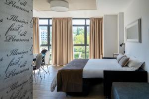 pokój hotelowy z łóżkiem i dużym oknem w obiekcie Alvear Suites w mieście Redondela