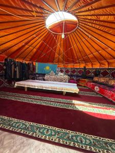 a room with a large orange tent with carpets in it at Юрты РАЯНА in Kurmenty