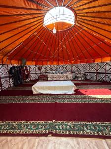 a room with an orange tent with a bed in it at Юрты РАЯНА in Kurmenty