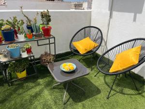 two chairs and a table with a bowl of oranges on it at Marbella Secret Attic in Marbella