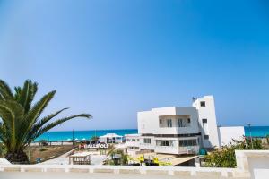 a building on the beach with the ocean in the background at Welcome to our Home Villetta Baia Verde Gallipoli in Baia Verde