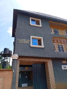 a black building with two windows and a door at Malebond Global Hotel in Mama +14 photos