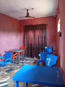 a room with tables and chairs and red walls at Malebond Global Hotel in Mama