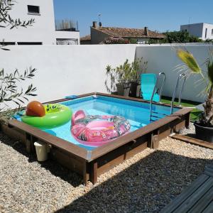 a swimming pool with a toy inflatable at Villa Harmony Climatisation Piscine semi enterrée Wifi Camargue in Saint-Just