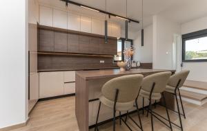 a kitchen with a counter with chairs and a table at Cozy Home In Turanj With Sauna in Turanj