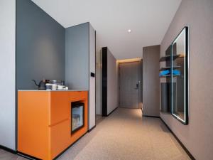 a room with a hallway with an orange counter and a room with a door at Atour S Hotel Lanzhou Wulipu Provincial People's Hospital in Lanzhou