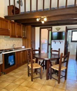 モンテ・ナイにあるAmareSardegna10のテーブルと椅子と冷蔵庫のあるキッチン