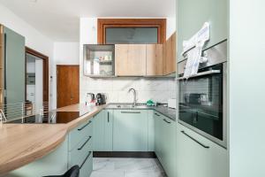 a kitchen with white cabinets and a wooden counter top at Casa MammaMarisa in Murano