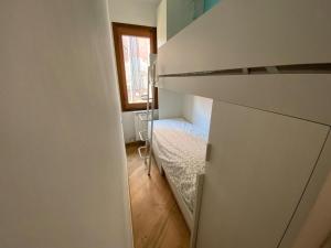 a small room with a bed and a window at Casa MammaMarisa in Murano