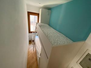 a small room with a bunk bed with a blue wall at Casa MammaMarisa in Murano