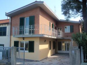 a house with a balcony on the side of it at Casa Vacanze immersa tra le colline, vicinissima al mare e con nuova piscina in Senigallia