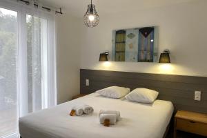 una camera da letto con due letti con asciugamani sopra di Villa Corée - Domaine Le Sherwood a Notre-Dame-de-Monts