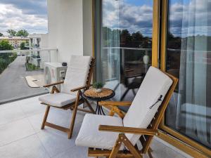 deux chaises et une table sur un balcon dans l'établissement Kairos Apartments -Atos - darmowy parking, klimatyzacja, à Olsztynek