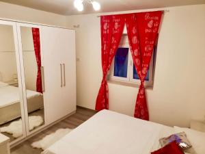 ein Schlafzimmer mit roten Vorhängen und einem Fenster in der Unterkunft Ferienwohnung für 8 Personen ca 85 m in Podstrana, Dalmatien Mitteldalmatien in Podstrana