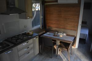 a small kitchen with a table and a stove at OasiHome in SantʼAndrea +14 photos