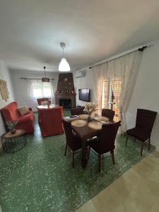 a living room with a table and chairs and a fireplace at Casita Rural La Rosa de la Huerta con chimenea interior in Monachil