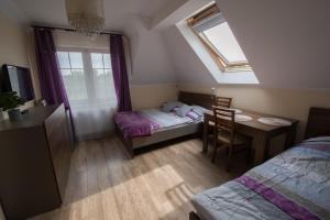a bedroom with a table and a bed and a window at Willa Hydrograf in Ustka