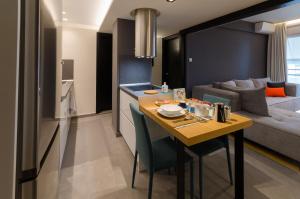 a kitchen and living room with a table and a couch at Above & Beyond Volos City Center Luxury Redefined in Volos