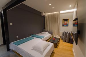 a bedroom with two beds and a table at Above & Beyond Volos City Center Luxury Redefined in Volos