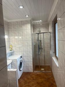 y baño con lavadora y ducha. en Dom letniskowy Kasia Rowy, en Rowy
